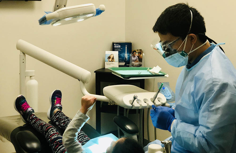 Safe dental care practices being performed for a patient by a dentist