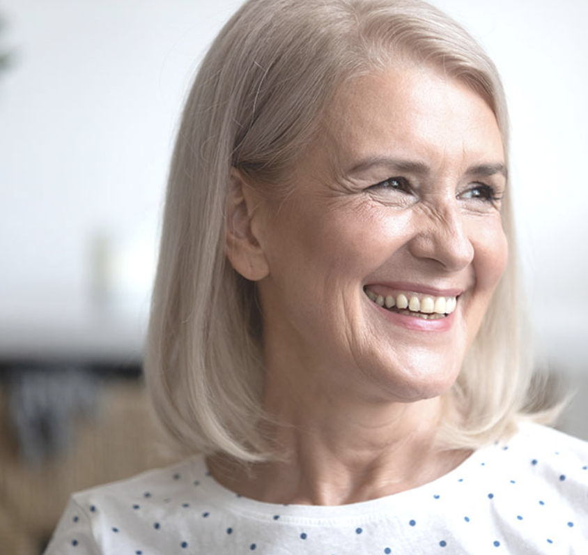A woman smiling after receiving dental implants