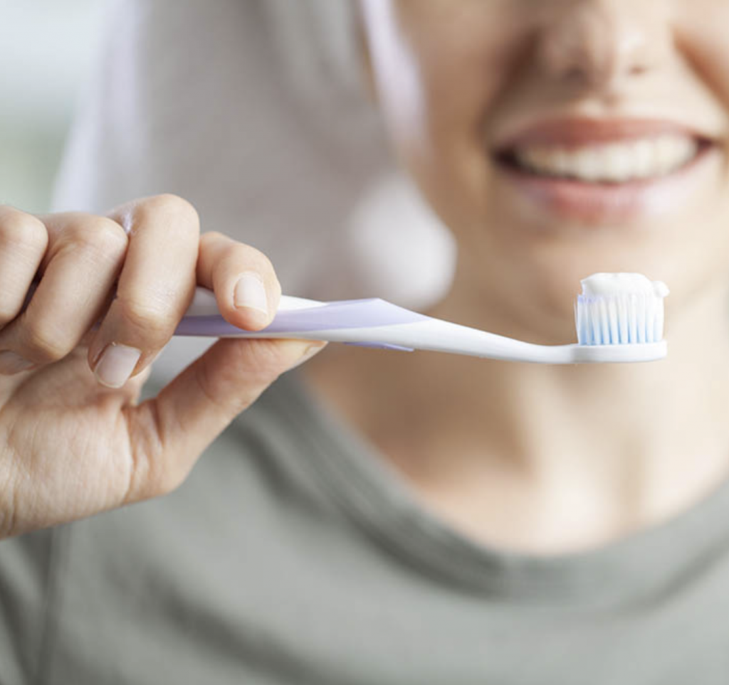A woman with a tooth brush, prepared to use the best brushing practices