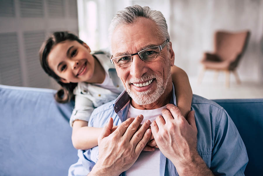 A man smiling with a child, post dental sealant procedure