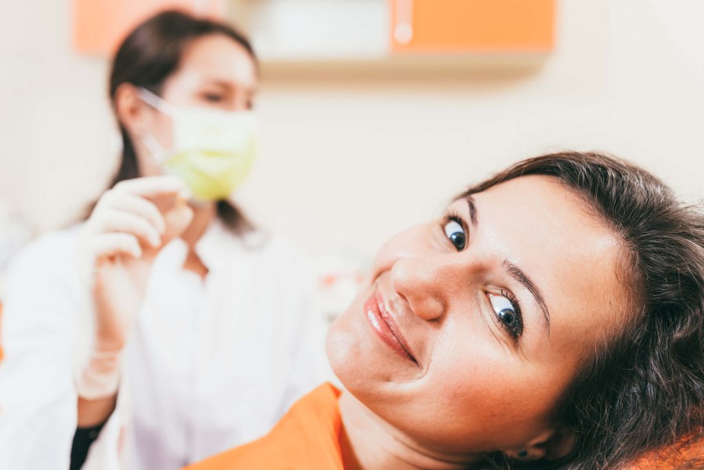 A woman smiling after a successful tooth extraction