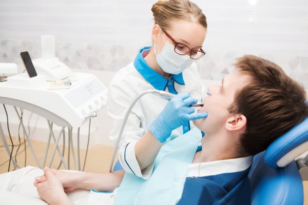 Dentist examining and working on young patient.